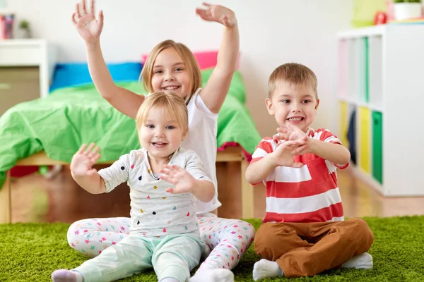 Group of happy kids sitting on floor at home — Stock Photo, Image