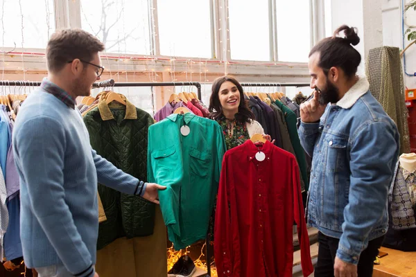 Друзья выбирают одежду в магазине винтажной одежды — стоковое фото