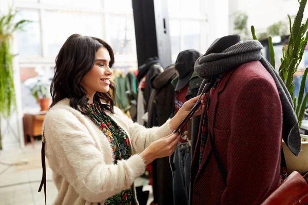 Mulher feliz escolhendo roupas na loja de roupas — Fotografia de Stock