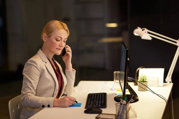 Mujer de negocios llamando a sartphone en la oficina nocturna — Foto de Stock