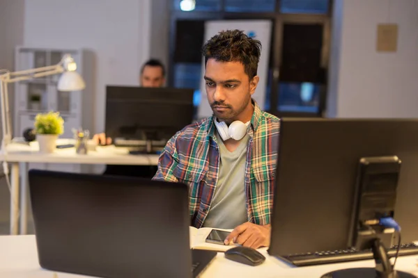 Homme créatif avec ordinateur portable travaillant au bureau de nuit — Photo