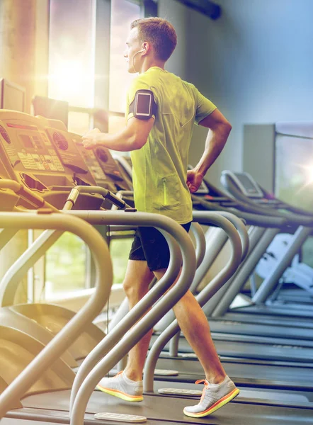 Mann mit Smartphone trainiert auf Laufband im Fitnessstudio — Stockfoto