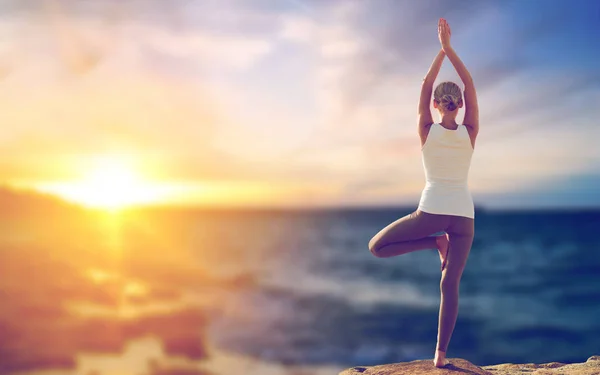 Mujer feliz haciendo yoga árbol pose sobre el mar —  Fotos de Stock