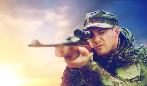 Soldier or hunter with gun aiming and shooting — Stock Photo, Image