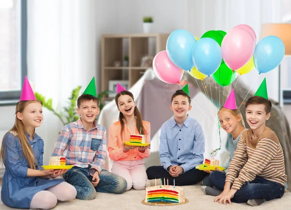 Boldog gyermekek, party kalap, születésnapi torta — Stock Fotó