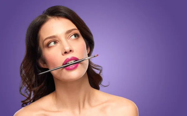 Smuk kvinde med fyldes op børste til læbestift - Stock-foto