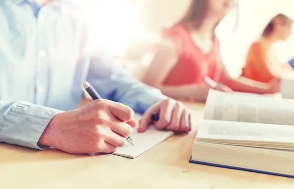 Primo piano dello studente che scrive sul taccuino a scuola — Foto Stock