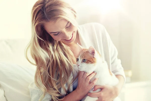 Ευτυχισμένος νεαρή γυναίκα με γάτα στο κρεβάτι στο σπίτι — Φωτογραφία Αρχείου