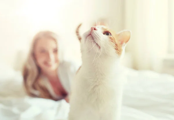 Ευτυχισμένος νεαρή γυναίκα με γάτα στο κρεβάτι στο σπίτι — Φωτογραφία Αρχείου