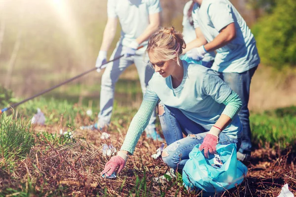 Voluntarios con bolsas de basura limpieza área del parque — Foto de Stock