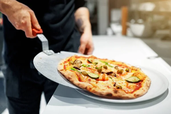 Cozinhe com pizza assada na casca na pizzaria — Fotografia de Stock