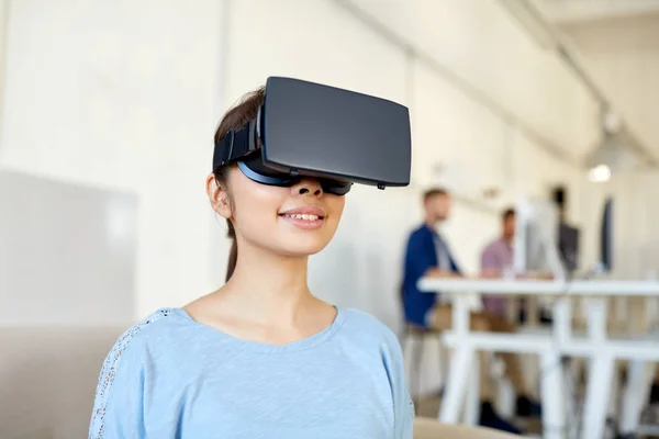 Счастливая женщина с гарнитурой виртуальной реальности в офисе — стоковое фото