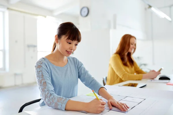 Female architect with blueprint working at office — Stock Photo, Image