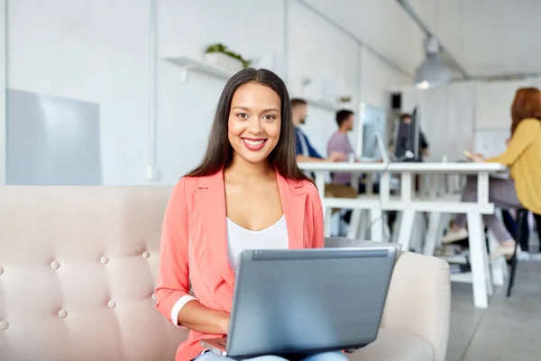 Mujer feliz con el ordenador portátil trabajando en la oficina — Foto de Stock