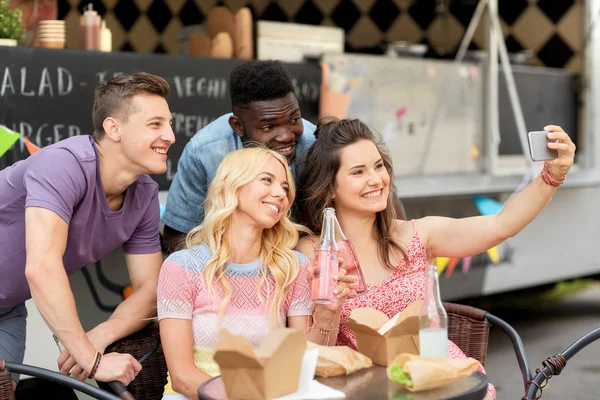 Jovens amigos felizes tomando selfie no caminhão de comida — Fotografia de Stock