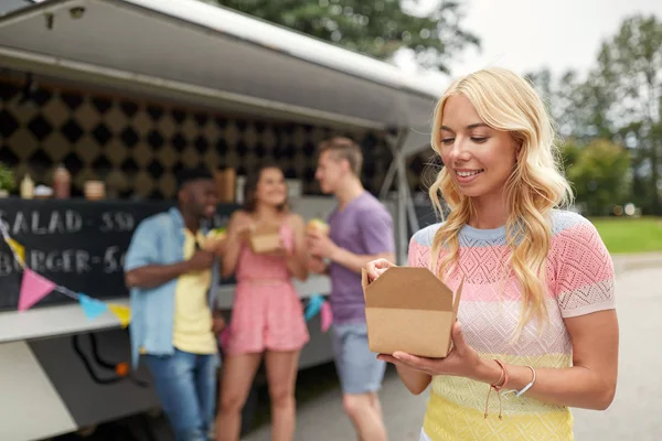 Happy woman with wok and friends at food truck — Stock Photo, Image