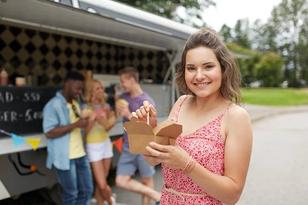 Happy woman with wok and friends at food truck — Stock Photo, Image