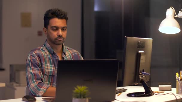 Hombre creativo con computadora trabajando en la oficina nocturna — Vídeos de Stock