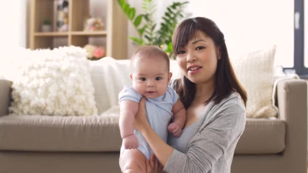 Feliz joven madre con pequeño bebé en casa — Vídeos de Stock