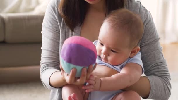 Madre feliz con el bebé y la pelota jugando en casa — Vídeos de Stock