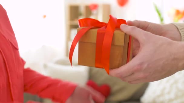Мужчина делает подарок женщине в день святого Валентина — стоковое видео