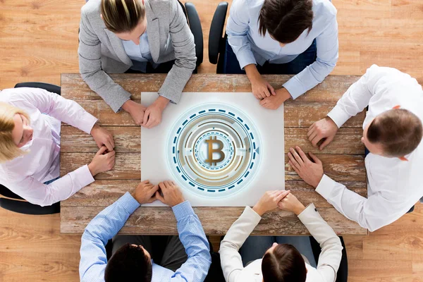 Equipo de negocios en la mesa con el icono de bitcoin — Foto de Stock