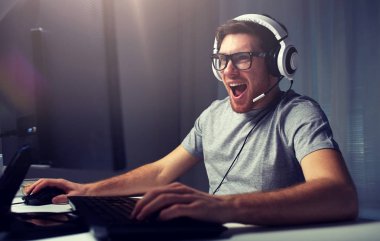 man in headset playing computer video game at home clipart