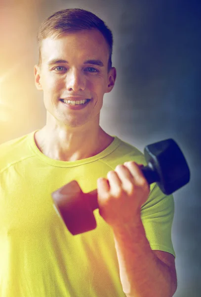 Homme souriant avec haltère dans la salle de gym — Photo