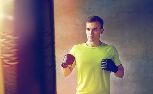 サンドバッグ ボクシング手袋の若い男 — ストック写真