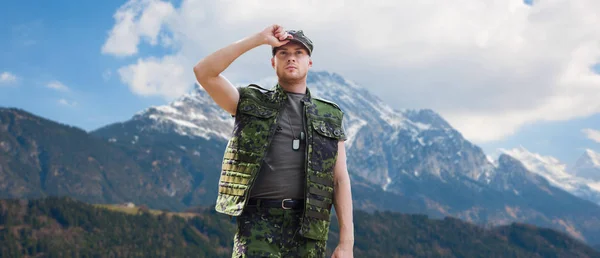 Żołnierz w mundurze wojskowym przez góry — Zdjęcie stockowe