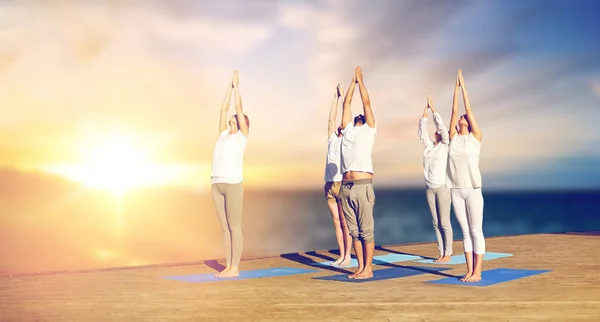 Grupo de personas haciendo yoga al aire libre — Foto de Stock