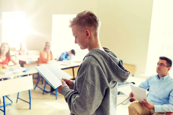 Estudiante con cuaderno y profesor en la escuela — Foto de Stock