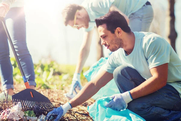 Voluntarios con bolsas de basura limpieza área del parque —  Fotos de Stock