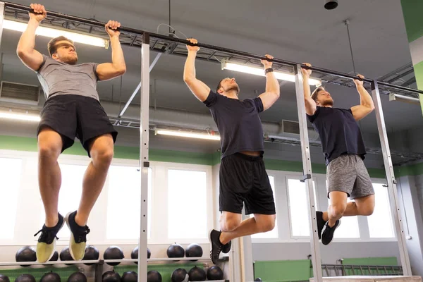 Csoport fiatal férfiak pull-up edzőteremben csinál — Stock Fotó