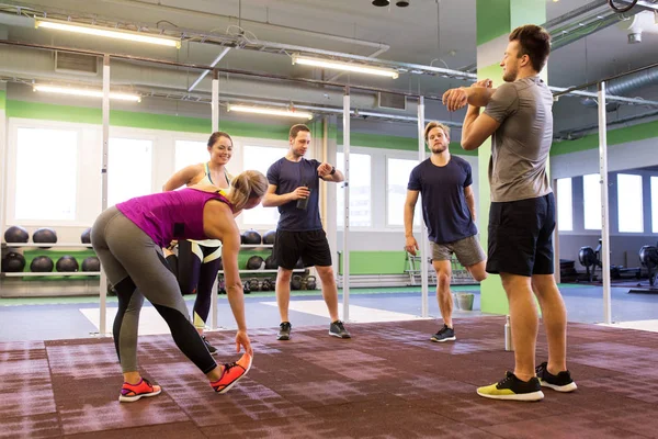 Gruppo di amici felici che si allungano in palestra — Foto Stock