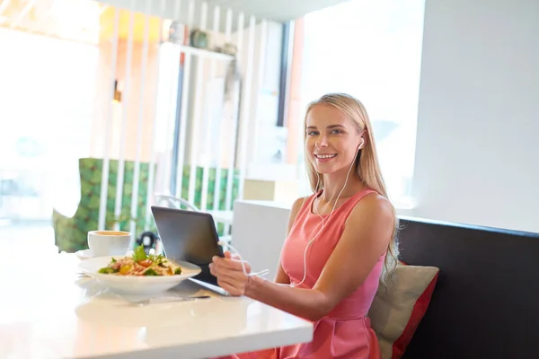 Szczęśliwa młoda kobieta z komputera typu tablet w restauracji — Zdjęcie stockowe