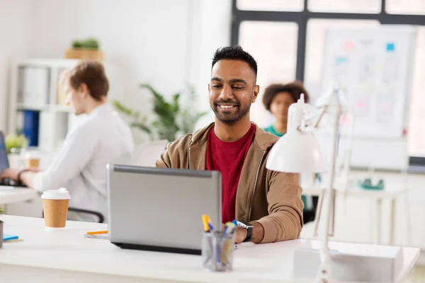 Hombre indio feliz con ordenador portátil en la oficina — Foto de Stock