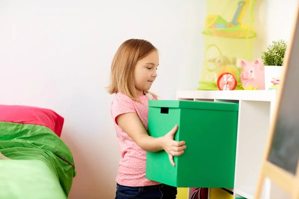 Счастливая маленькая девочка с игрушечной коробкой дома — стоковое фото