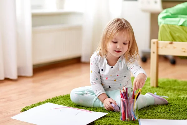 Happy little girl with crayons drawing at home — Stock Photo, Image