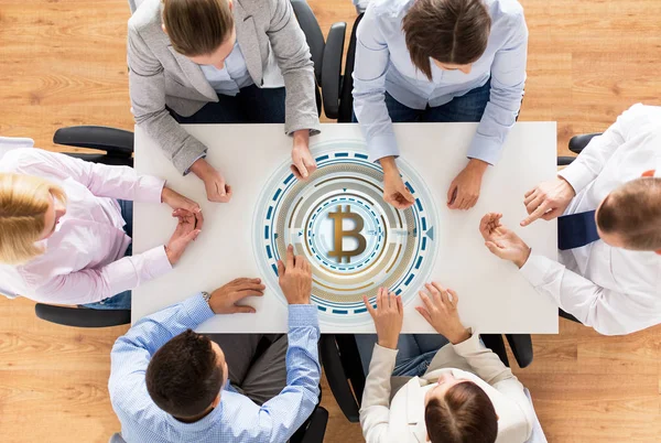 Equipo de negocios en la mesa con el icono de bitcoin — Foto de Stock