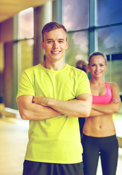 Glimlachende man en vrouw in de sportschool — Stockfoto