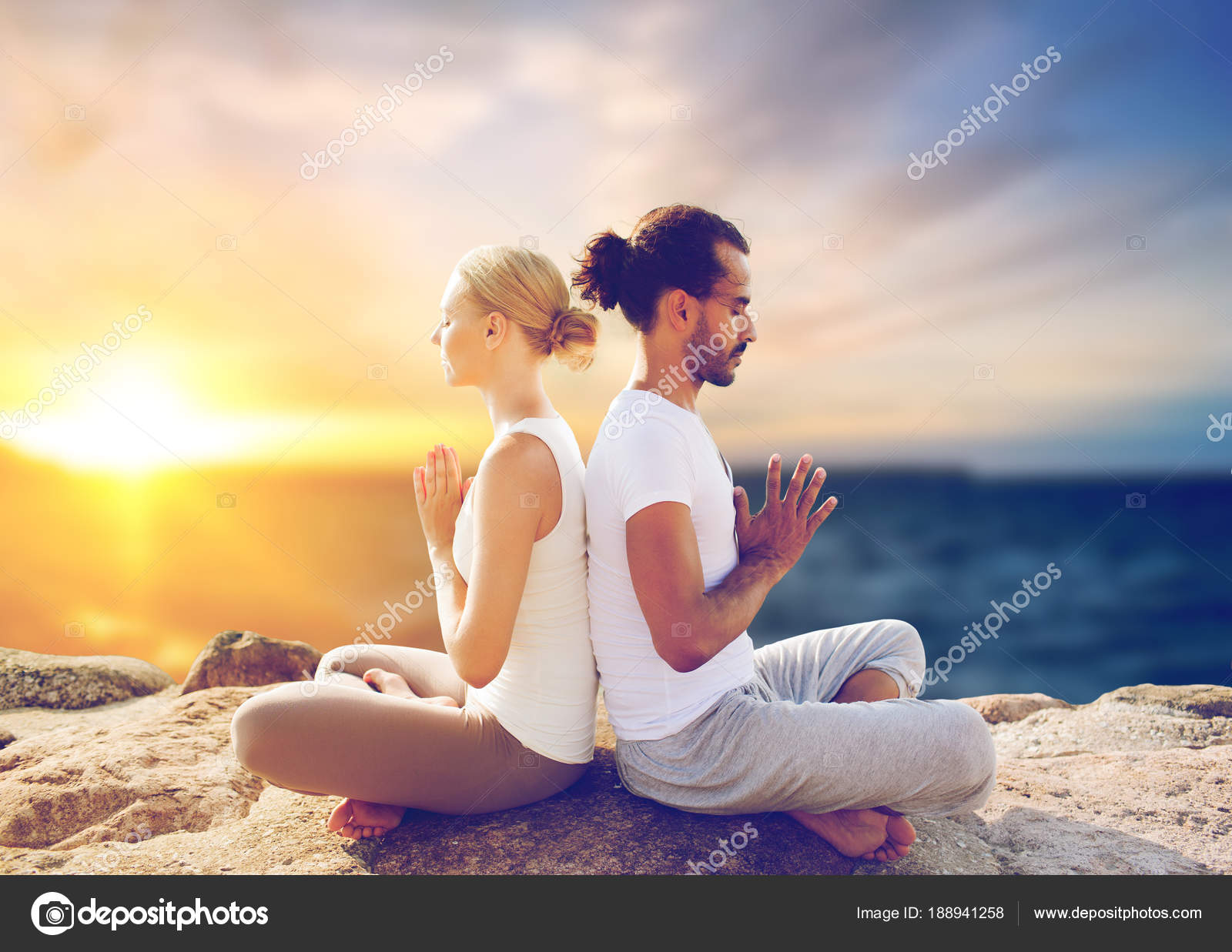 Happy couple making yoga and meditating outdoors Stock Photo by ©Syda