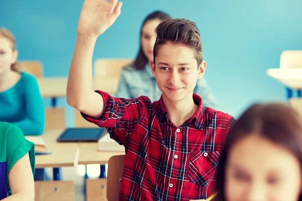 Student szczęśliwy chłopiec podnoszenie ręki w szkole lekcji — Zdjęcie stockowe