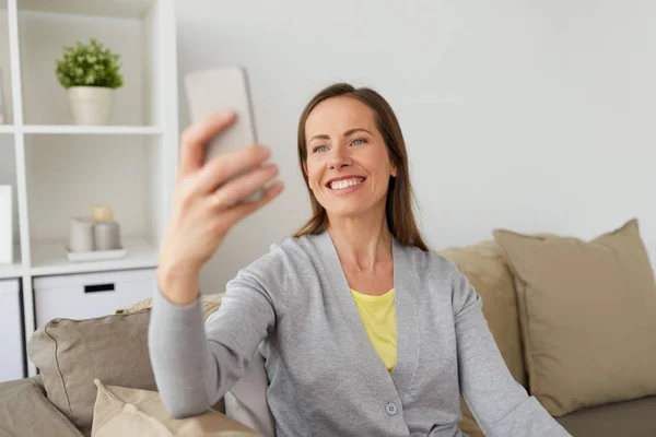 Gelukkige vrouw die selfie door smartphone thuis — Stockfoto
