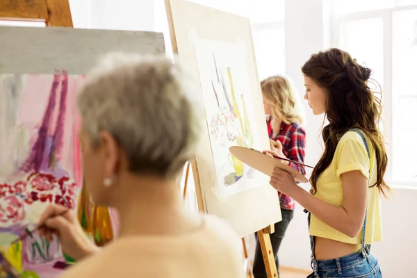 Woman with easel painting at art school studio — Stock Photo, Image