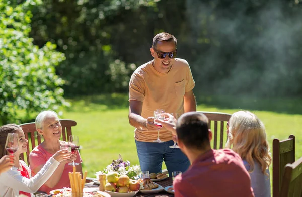 Família feliz ter jantar ou festa no jardim de verão — Fotografia de Stock
