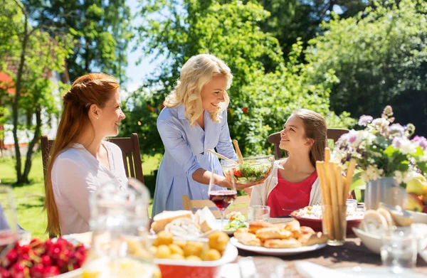 Счастливая семья, ужинающая в летнем саду — стоковое фото