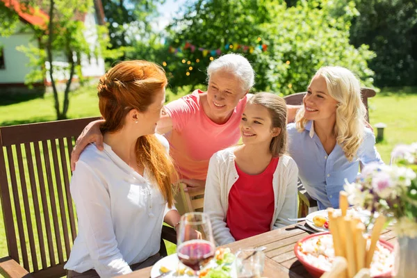 Lycklig familj äter middag på sommarträdgård — Stockfoto