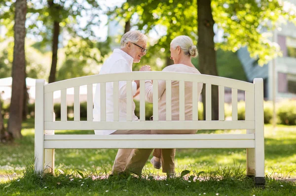 Feliz casal sênior sentado no banco no parque — Fotografia de Stock