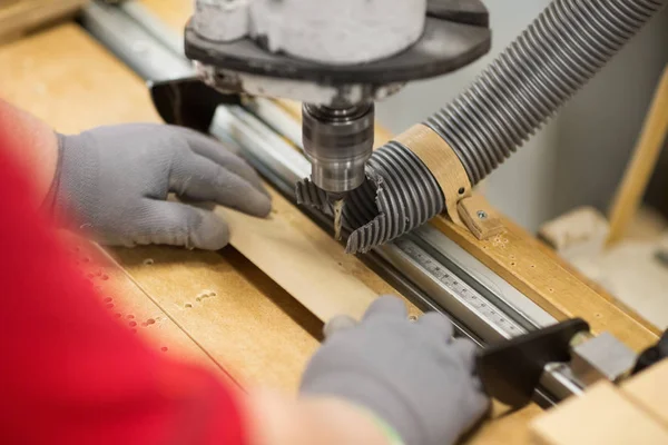 Carpenter with drill press and board at workshop — Stock Photo, Image